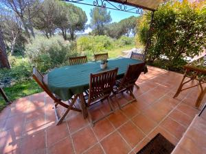 圣拉斐尔VILLA Saint Raphael Valescure Piscine Clim Wifi Golf的天井上摆放着绿色的桌椅