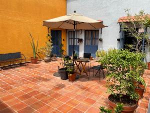 瓜达拉哈拉Casa Arrayan的天井配有桌子、雨伞和植物
