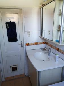 林茨Doppelhaushälfte mit Garten的一间带水槽、镜子和门的浴室