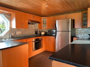 拜圣保罗Paradis de Charlevoix - Loft的厨房配有木制橱柜和不锈钢冰箱。