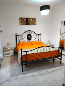 圣尼科拉阿尔切拉Villetta Clorinda的一间卧室配有一张带橙色床罩的床