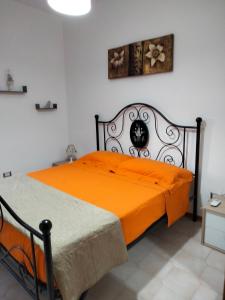 圣尼科拉阿尔切拉Villetta Clorinda的一间卧室配有橙色的床和白色的墙壁