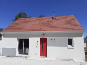 希特奈La Petite Salamandre的一间白色的小房子,有红色的门