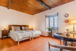 萨尔Quinta de Santo Antonio的一间卧室配有一张床、一张桌子和一个窗户。