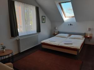 StrzezeniceDworek Natury的一间卧室设有床、两扇窗户和一把椅子
