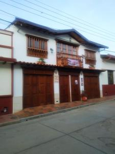 萨帕托卡La Casa de Mamá Tere的白色的房子,设有木门和阳台