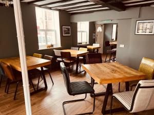 布由德利Severn Valley Guest House的餐厅设有木桌、椅子和窗户。