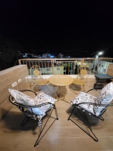 提比里亚ספא מור Spa Mor的夜间阳台上的桌椅
