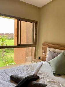 马拉喀什Prestigia Golf的一间卧室设有一张床和一个大窗户