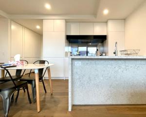 墨尔本Readyset Apartments at Marque的厨房配有白色橱柜和桌椅