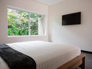 布里斯班Inala Hotel的白色的卧室设有床和窗户