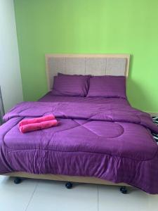 哥打巴鲁Risqi Apartment 2 bedroom Wakaf Che Yeh的紫色的床和两个粉红色枕头