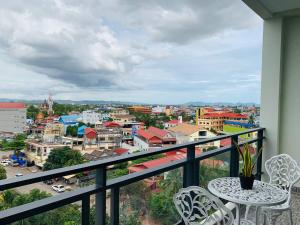 贡布Kampot Sunny Hotel的阳台配有桌椅,俯瞰着城市