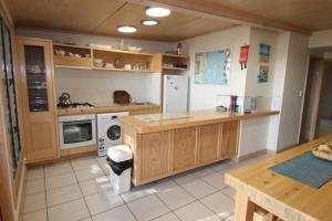 Cowan Cowan卡万卡万吉特度假屋的厨房配有木制橱柜、洗衣机和烘干机