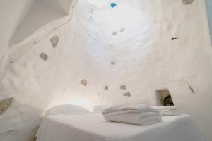 莱乌卡Villa Tina ai Piedi del Faro di Leuca的一张桌子上的两条毛巾,房间带岩石墙