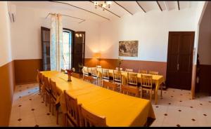 马斯诺Masia La Bomba的大型用餐室配有黄色的桌椅