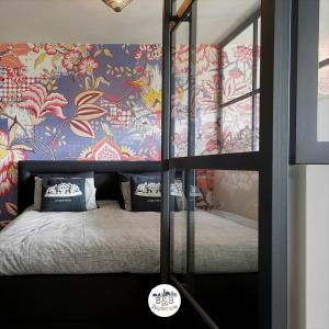 宾斯霍滕BB aan de Zuyderzee的一间卧室配有一张带花卉壁纸的床