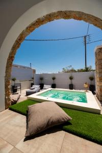 佩里沃罗Kasteli Suites的一座带拱门的庭院中央的游泳池