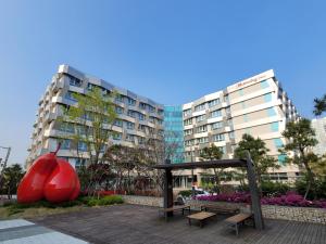 束草市Chungchoho Best Hotel的公园里的红苹果雕像和长凳