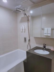 束草市Chungchoho Best Hotel的白色的浴室设有水槽和淋浴。