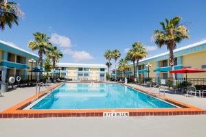奥兰多Garnet Inn & Suites, Orlando的棕榈树度假村的游泳池