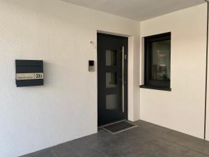 莱茵河畔凯尔Mittendrin Ortenau -keine Monteurwohnung-的白色房间的一个黑色门,窗户