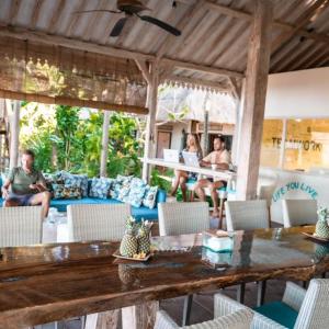 特贾库拉慈利艾玛斯海滨度假村的一群人坐在带桌子的庭院里
