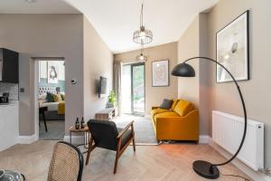 JesmondChelmsford Lofts - High-spec luxury apartments的客厅配有黄色的沙发和桌子