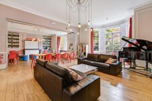 伦敦Lee Abbey London的一间带两张真皮沙发的客厅和一间厨房