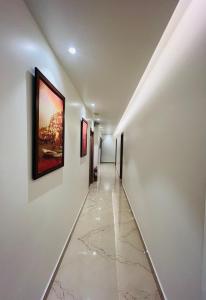 瓦拉纳西Sugar Stars Inn的走廊上设有白色的墙壁和墙上的绘画作品