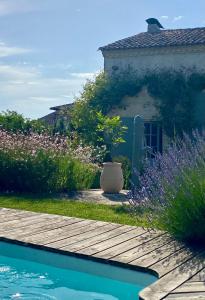 圣日的贡M de Maumey的一座带游泳池的花园以及一座鲜花盛开的房子