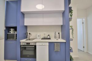 内坦亚Cozy and stylish 1-bedroom apartment的厨房配有蓝白色橱柜和水槽