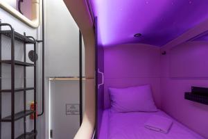 利沃夫Capsule Hotel Constellation 89的紫色天花板小房间内的紫色床