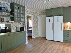 永比Bolmen Bed - Vandrarhem的厨房配有绿色橱柜和白色冰箱