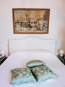 帕多瓦Casa Locatelli - Apartment Deluxe & Suite的一张带两个枕头的白色床和上面的绘画