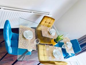 伯明翰Mayfair Place - Cosy 3 Bedroom House with Free Parking的一张带蓝色椅子的桌子和一张带盘子的桌子