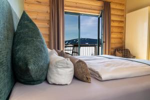 奥泊维森塔尔Hotel Jens Weissflog的卧室配有带枕头的床铺和窗户。