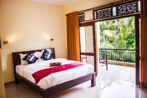 八丹拜Bali 85 Beach Inn的一间卧室设有一张床和一个滑动玻璃门