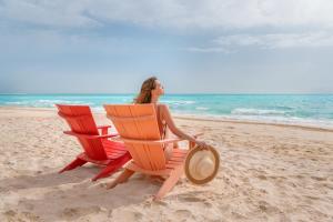 阿莱曼Al Alamein Hotel的坐在海滩上两个沙滩椅的女宾