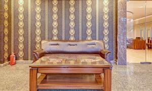 勒克瑙Treebo Trend Silver Stallion的一张皮沙发,位于带桌子的房间