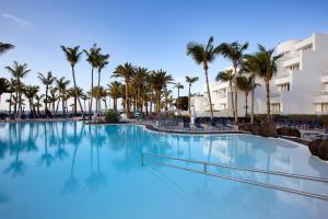 卡门港拉赫里亚时尚酒店的一座棕榈树和建筑的大型游泳池