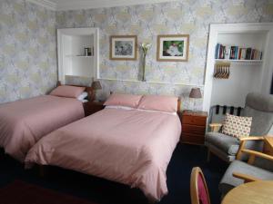邓迪Athollbank Guest House的一间卧室配有两张床和椅子