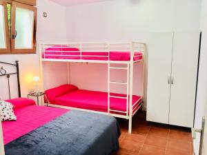 苏安塞斯Apartamentos Casa Carmen的一间卧室配有两张双层床和粉红色床单