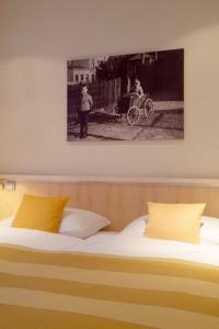 费尔贝特罗勒德宾馆的一张带两个枕头的床和一张汽车照片
