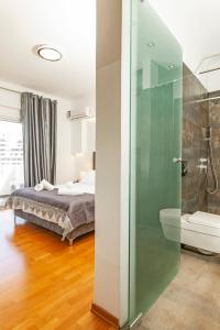 依克希亚Unique Sea & Sunset Residence的一间卧室设有一张床和一个玻璃淋浴间