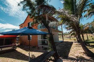 Rodrigues IslandGravier beach house的坐在房子前面的蓝伞