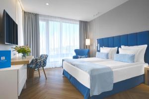 索佐波尔Viva Mare Beach Hotel by Santa Marina的一间卧室配有一张大床和蓝色床头板
