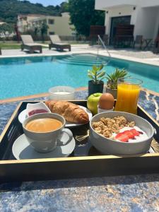 普莱诺斯Κimiro Hotel Tsilivi的池畔餐桌上的早餐盘