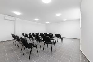 蒂豪尼Hérics Apartman的白色墙壁的房间的一排椅子