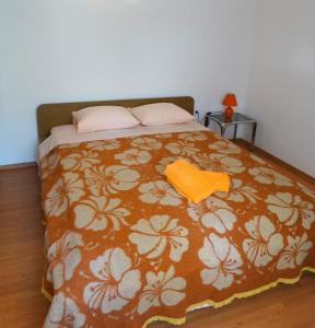 茨里克韦尼察Apartman Crikvenica 30048 - Jasna的一间卧室配有一张带橙色毯子的床